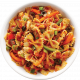 Plato de pasta farfalle con salsa de tomate, pimientos y verduras, servido en un tazón blanco.