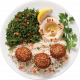 Plato de comida mediterránea que incluye arroz, ensalada de perejil, hummus, tres falafel dorados y una rodaja de limón. Ideal para una comida saludable y sabrosa.