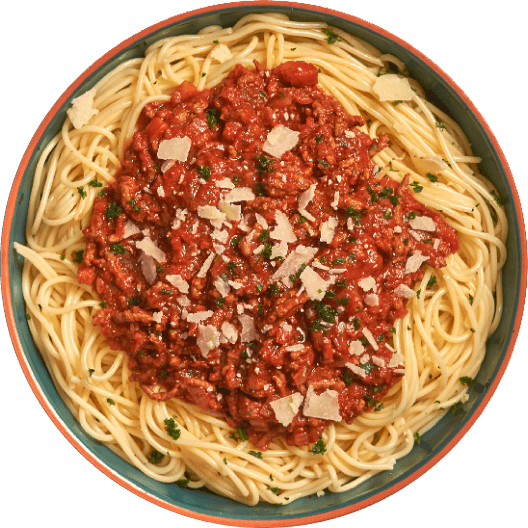 Plato de espagueti servido con salsa de carne roja, decorado con queso rallado y hierbas frescas, presentado en un tazón colorido.
