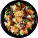 Ensalada fresca con lechuga, tomates cherry, pollo frito, queso rallado y aderezo, presentada en un plato negro. Ideal para una comida saludable y sabrosa.