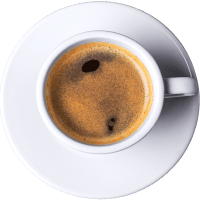 Taza de café espresso servido en un plato blanco, con crema en la superficie y burbujas visibles.