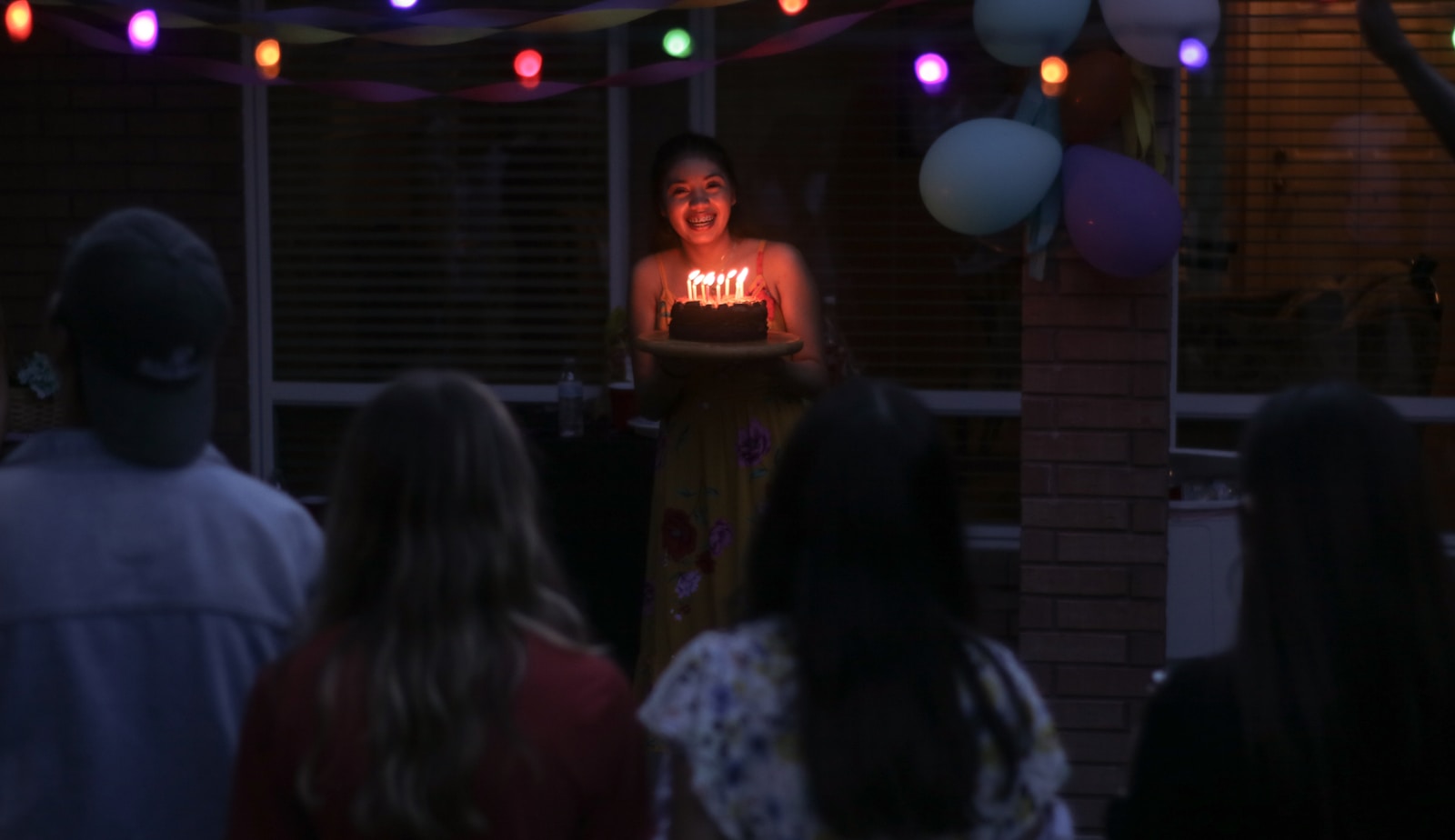people watching women holding a cake close-up photography